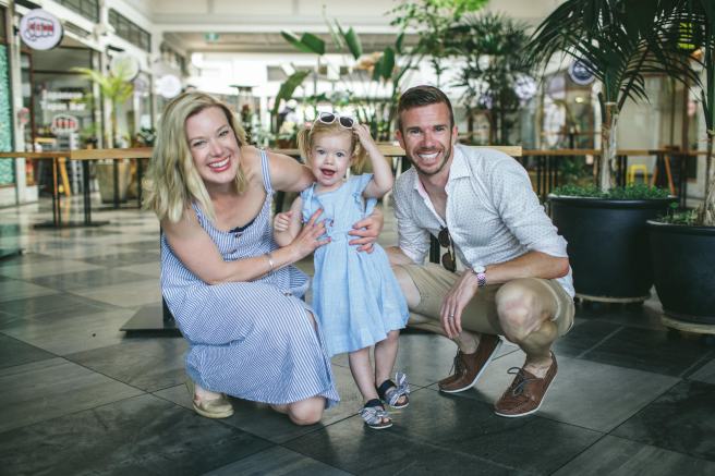 A man, a woman and a toddler smiling